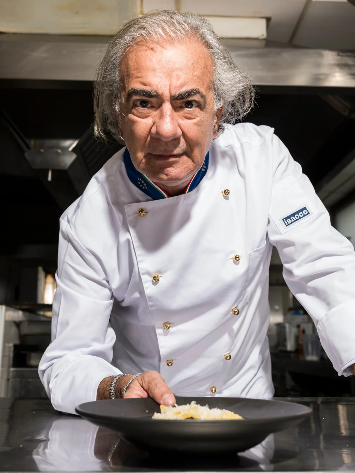 Lo chef al passe rifinisce un piatto