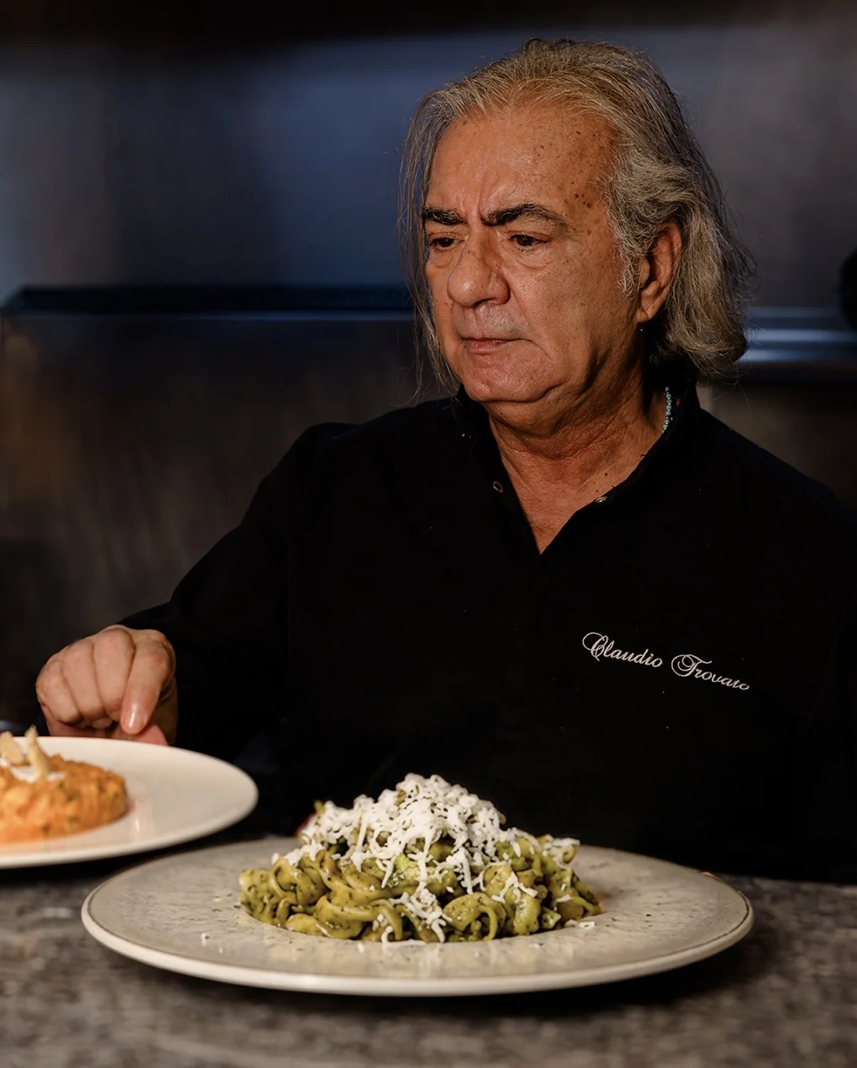 Lo chef con due piatti di pasta