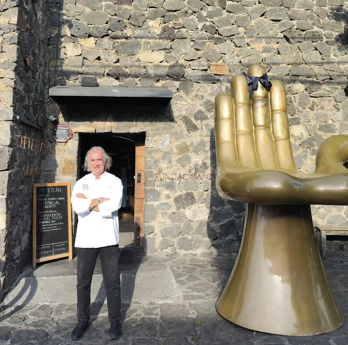 Lo chef Claudio Trovato davanti a Tetetlán, a Città del Messico, accanto alla scultura della mano dorata di Pedro Friedeberg