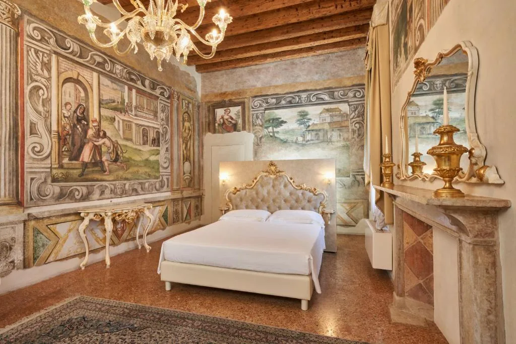 Una sala affrescata della villa, con lampadario di Murano e camino in marmo.