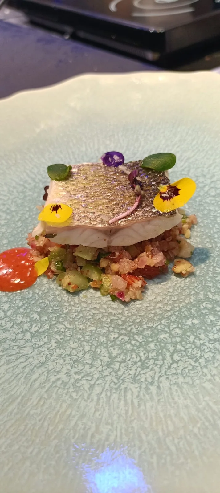 Filetto di pesce dalla pelle croccante su tabulé agli agrumi con fiori eduli