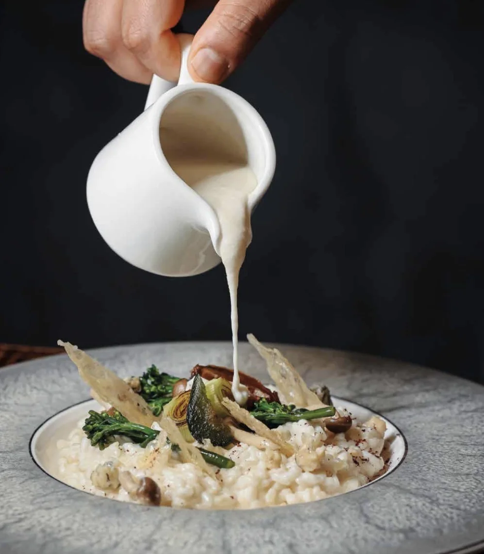 Risotto cremoso con salsa versata, broccoletti e cialde croccanti