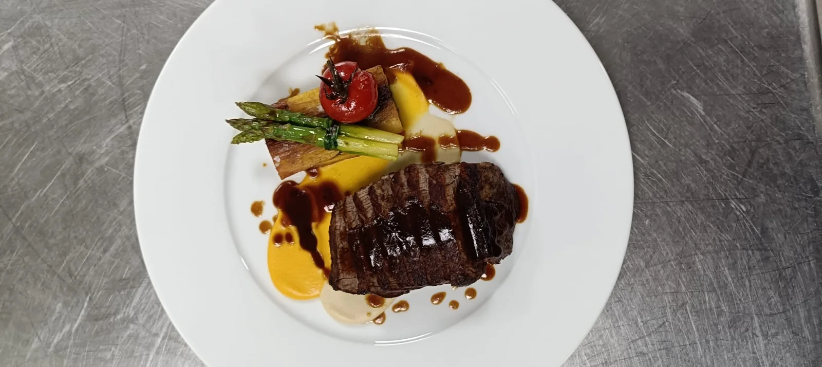 Tagliata di manzo glassata con asparagi, pomodorino confit e due creme