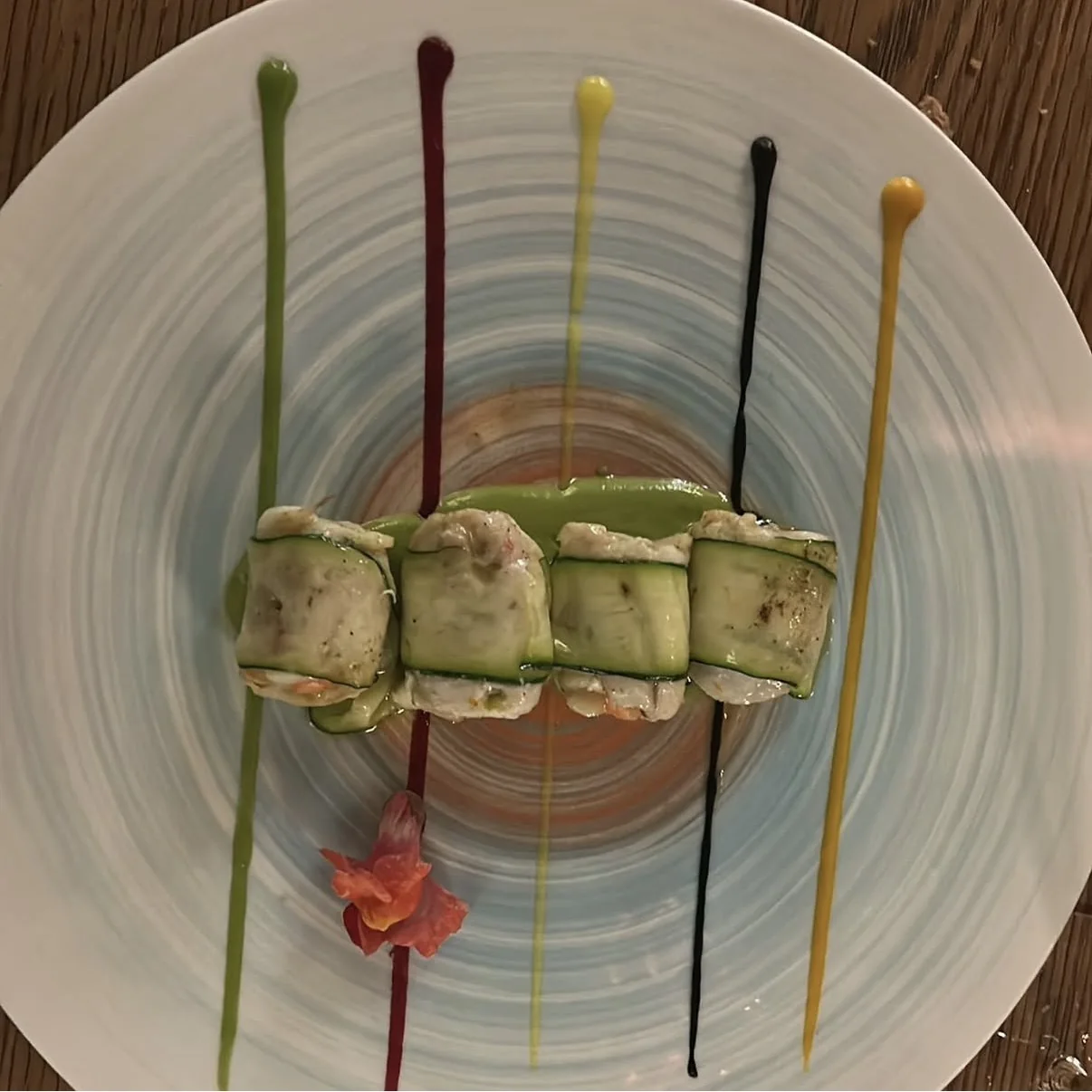 Involtini di zucchine su un arcobaleno di salse colorate